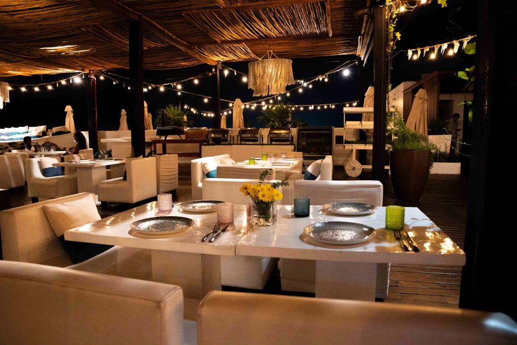 Beachfront restaurant terrace lit by string lights at night