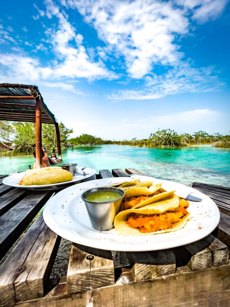Tacos and salsa on a wooden dock over the Bacalar lagoon